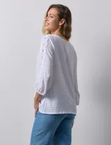 Blusa amarilla texturada con escote redondo y mangas 3/4 con puño elastizado. Aplique de broderie en escote y mangas. Marca Ruby Rd.
