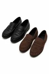 Mocasines de cuero negro con diseño clásico, punta redondeada con costuras fruncidas y tira decorativa en el empeine.