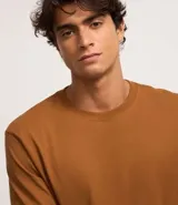 Remera de manga larga con cuello redondo, confeccionada en algodón. Presenta un corte comfort holgado y una pequeña etiqueta decorativa en el bajo.