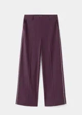 Pantalon de corte recto en color morado oscuro, con tiro medio y detalle de ribete (piping) en contraste a lo largo de las piernas. Cuenta con bolsillos laterales, cierre oculto y trabillas para cinturón.