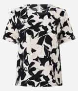 Blusa de manga corta con escote redondo y estampado floral abstracto en blanco y negro. Presenta costuras decorativas en contraste en el cuello y los puños.