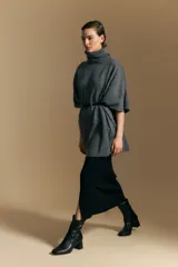 Poncho de tejido de punto color gris, con cuello alto y mangas amplias de diseño holgado.