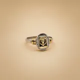 Anillo de diseño tipo sello con cuerpo de plata 925 y placa central rectangular de oro 18k con el símbolo del caduceo de contaduría grabado.