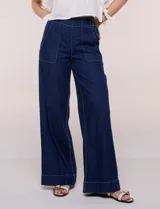 Jean de tiro alto y pierna amplia de corte wide leg, confeccionado en denim azul. Presenta cintura plana en el frente y elastizada en la espalda, bolsillos delanteros aplicados estilo parche y pespuntes a contrapunto.