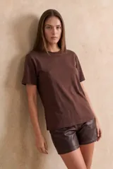 Remerón oversize de viscosa color negro con sutiles destellos brillantes, de manga corta y cuello redondo.