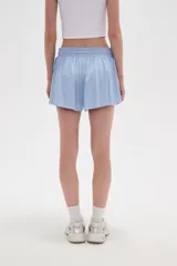 Short de poliéster color negro, de calce holgado y tiro alto, con cintura elástica y cordón ajustable.