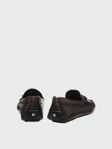 Mocasines de cuero napa color marrón oscuro, con herraje metálico con logo en el empeine y suela plana.