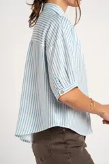 Blusa de manga corta con estampado de rayas verticales celestes y blancas, cuello camisero, escote en V y cierre frontal con botones.