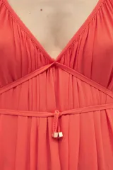 Vestido largo color coral, sin mangas, confeccionado en crepe. Presenta breteles finos que se atan para regular el largo y dos tiras en el pecho que se pueden atar de diferentes maneras.