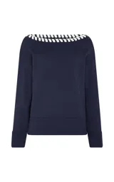 Sweater azul marino de tejido de punto con escote barco, detalle contrastante en color blanco a lo largo del borde, mangas largas con hombros caídos y ajuste ligeramente holgado.
