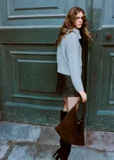 Cardigan de punto gris con cuello camisero, cierre frontal de botones y mangas largas.