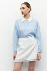 Minifalda de tweed color blanco con flecos en el ruedo.