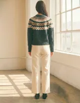 Buzo de punto marca Pinch con diseño nórdico geométrico en la parte superior. Presenta cuello redondo, mangas largas y un tono gris oscuro predominante con detalles en beige y blanco.