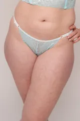 Tanga de encaje con diseño floral en color acqua, con tiras laterales blancas regulables y elástico en la cintura.