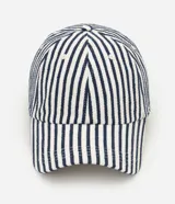 Gorra estilo dad hat con estampado de rayas verticales azul marino y blancas, visera curva y ojalillos bordados.