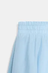 Falda midi de corte en A, color blanco, confeccionada en algodón con cintura elástica de tiro alto y forro interior a tono.