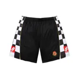 Short deportivo negro con paneles laterales a cuadros blancos y negros. Presenta detalles en color dorado, el logo de Supreme en la parte inferior de los laterales y un escudo circular bordado en la pierna derecha.