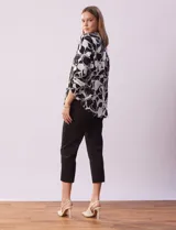 Blusa de gasa estampada con flores rojas y blancas, marca Floral & Ivy. Tiene cuello a la base con escote en V y mangas tres cuartos regulables con presilla y botón.