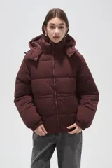 Campera puffer de corte holgado, color beige, con capucha desmontable, cierre frontal y puños elásticos.