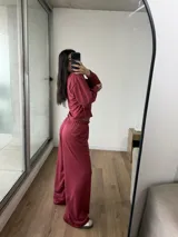 Conjunto de dos piezas color bordó, compuesto por un buzo de cuello redondo con mangas largas y un pantalón de corte holgado con cintura elástica.