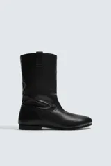 Bota de caña media fabricada en piel lisa, con diseño minimalista, tiradores laterales y suela a tono con ligero tacón.