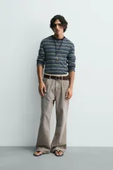 Pantalón de pana de corte flare, color verde oliva desgastado, con cinco bolsillos y cierre frontal de cremallera y botón.