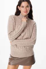 Sweater de tejido de punto con textura de ochos, cuello alto con cierre frontal, manga larga y puños y ruedo acanalados.