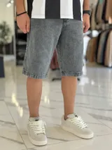 Bermuda de jean de corte baggy y tiro medio, con diseño clásico de cinco bolsillos y lavado claro.