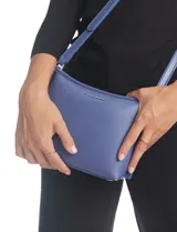 Cartera tipo bandolera Tahari color azul, con diseño estructurado y cierre metálico superior. Incluye una correa larga regulable y un mini monedero independiente enganchado a la misma. Presenta logo metálico frontal y herrajes plateados.