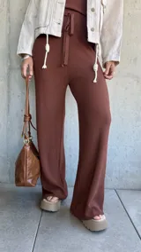 Pantalón marrón de tejido waffle con corte palazzo, cintura alta y lazo ajustable.