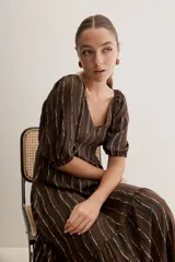 Vestido largo celeste con estampado botánico en tonos marrones, escote en V, mangas cortas abullonadas y falda con volado en el bajo.