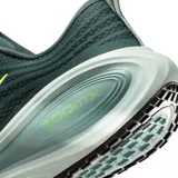 Championes de running Nike Vomero Plus, color verde oscuro con logo Nike Swoosh en amarillo neón. Presentan una suela gruesa con amortiguación visible que dice "ZOOMX".