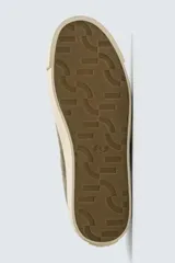 Zapatilla de cordones confeccionada en piel con acabado de serraje. Presenta un diseño liso con detalle de color a contraste en el talón y suela plana de goma a contraste.