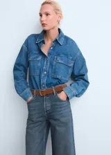 Pantalón de jean estilo wide leg con tiro alto, confeccionado en tejido de algodón. Presenta diseño de cinco bolsillos, cierre de botones y trabillas para cinturón.