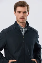 Campera liviana de nylon color azul marino, con cuello alto, cierre frontal y puños y dobladillo en elástico tejido.