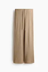 Pantalón de punto color marrón, de tiro medio con cintura elástica, cordón ajustable y corte ancho.