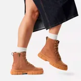Bota de caña media Sorel, confeccionada en piel de plena flor impermeable color tostado. Presenta cierre de cordones con ojales metálicos, tirador en el talón y una suela de caucho moldeado con diseño robusto y dentado.