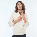 Sweater de punto color beige claro, con cuello alto y cierre frontal parcial de cremallera. Presenta puños y bajo acanalados.