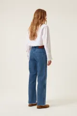 Pantalón de jean azul de tiro medio y corte recto, con terminación desflecada y detalles de trenzas en los laterales.