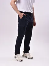 Pantalón cargo negro con cintura elástica ajustable con cordón, bolsillos laterales y traseros con solapa.