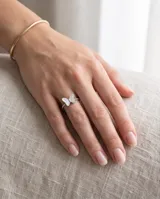 Anillo de acero con diseño de mariposa y apliques de nácar, con banda texturizada de pequeñas esferas.