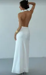 Vestido largo blanco de tela tricotada, con escote halter y abertura en la pierna.