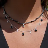 Collar de plata 925 con cadena de eslabones y dijes colgantes de espinela negra redondos y estrellas caladas.