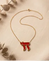 Collar de acero con baño de oro y dije en forma del símbolo Jai esmaltado en rojo, con cadena fina de eslabones.