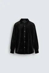 Sobrecamisa de corte relajado confeccionada en tejido de terciopelo elástico, con cuello solapa, manga larga con puños abotonados y cierre frontal de botones.