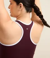 Top deportivo sin copa, color azul marino, con escote en U y espalda tipo nadador. Presenta ribetes contrastantes blancos en el escote y los bordes de las sisas.