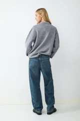 Jean de tiro medio con corte barrel y ajuste relajado, confeccionado en denim de algodón. Presenta diseño clásico de cinco bolsillos, cierre frontal con cremallera y botón metálico.