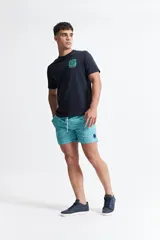 Short de baño celeste con estampado de motivos marinos en blanco. Tiene cintura elástica con cordón ajustable, dos bolsillos laterales y uno trasero.