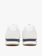 Championes de diseño runner de Tommy Hilfiger, confeccionados en una combinación de textil y cuero en color blanco, con detalles en gris claro, azul marino y suela de goma color caramelo.