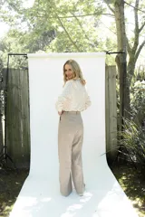 Pantalón de lino de corte sastrero, tiro medio, con pierna recta y pinzas en el frente.